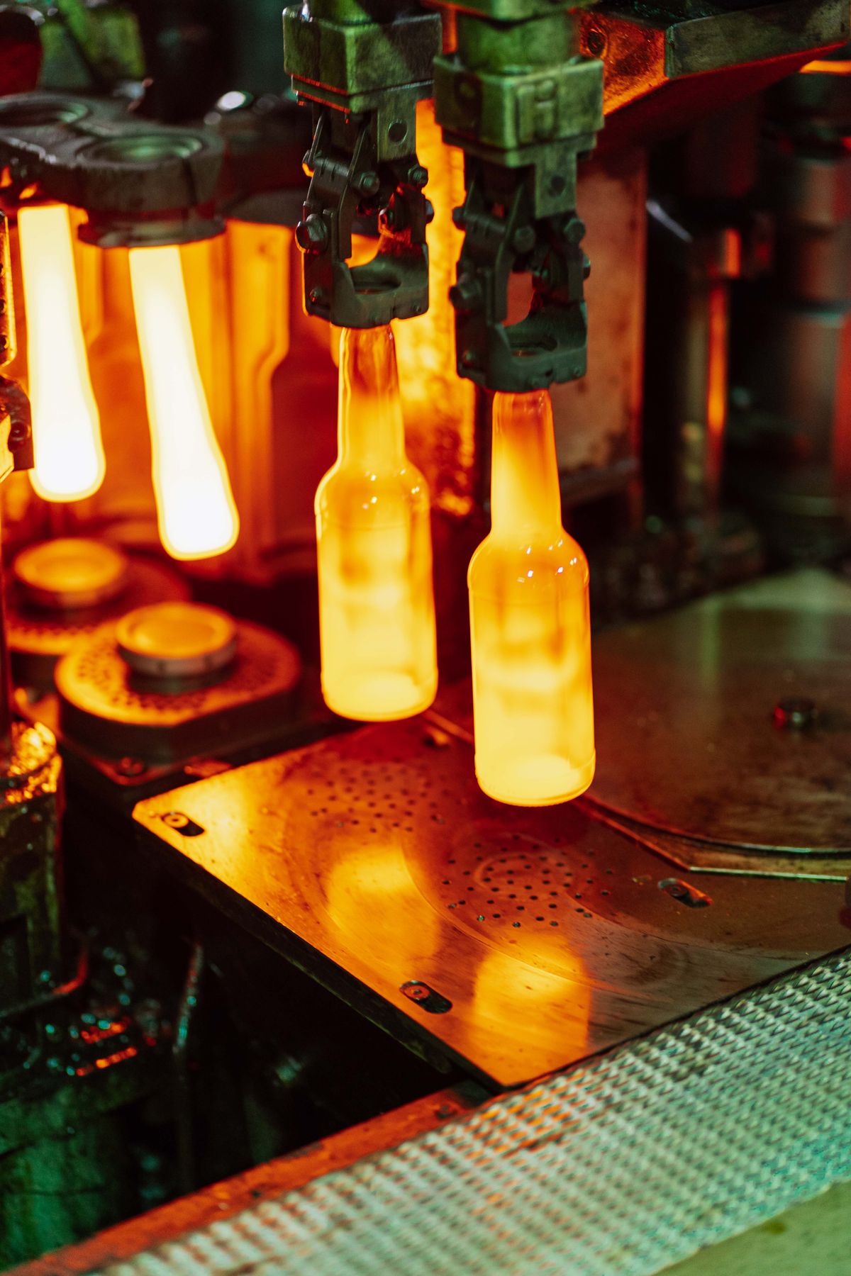 Hot glass bottles at forming machinery, photographed in a third-party glass factory